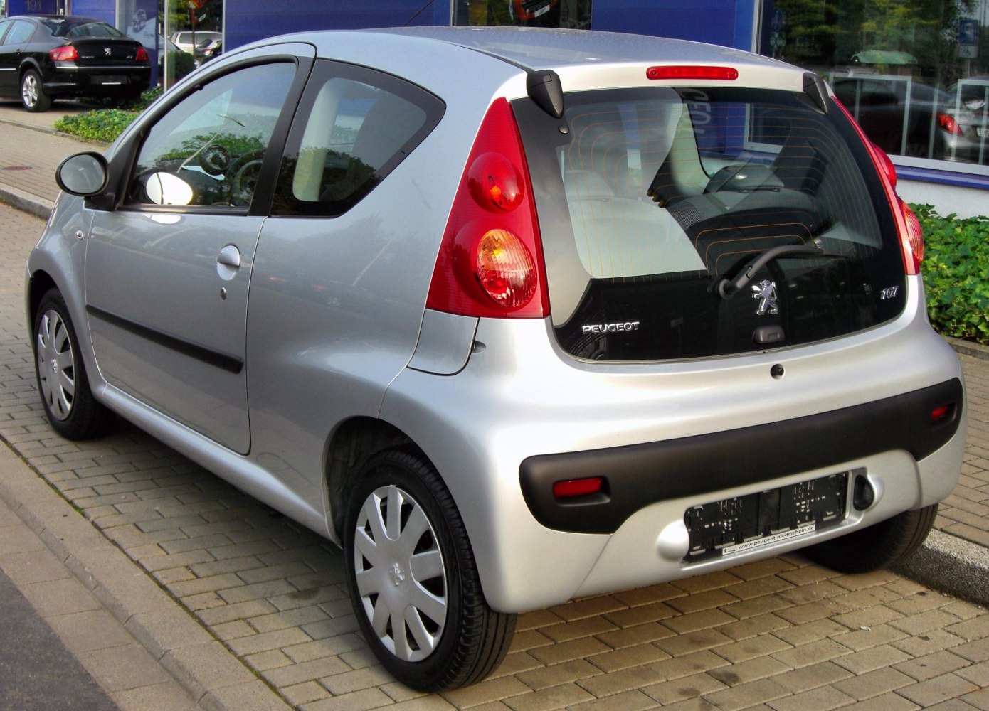 Rear view of a compact silver 3-door hatchback with distinct taillights and black bumper