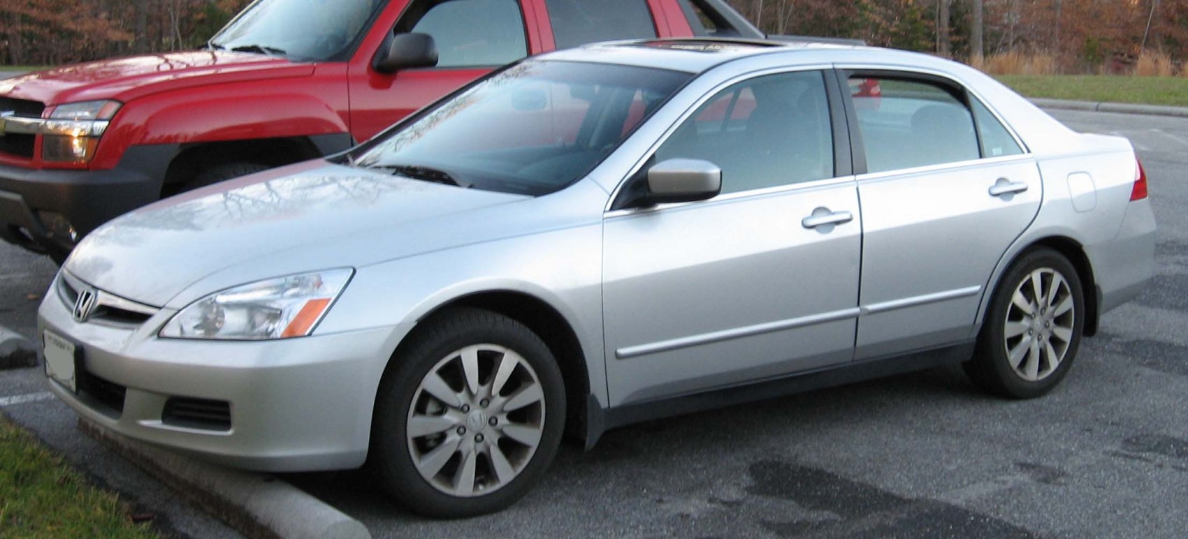 Silver sedan front side view with alloy wheels parked