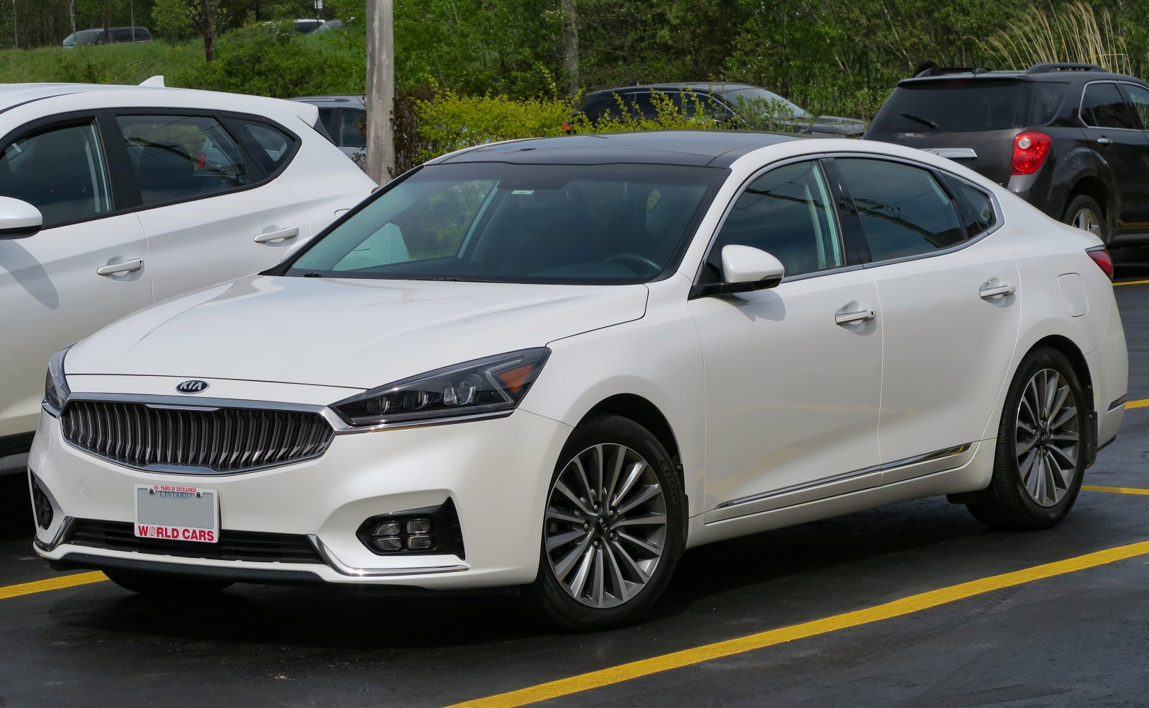 White luxury sedan with prominent front grille and alloy wheels