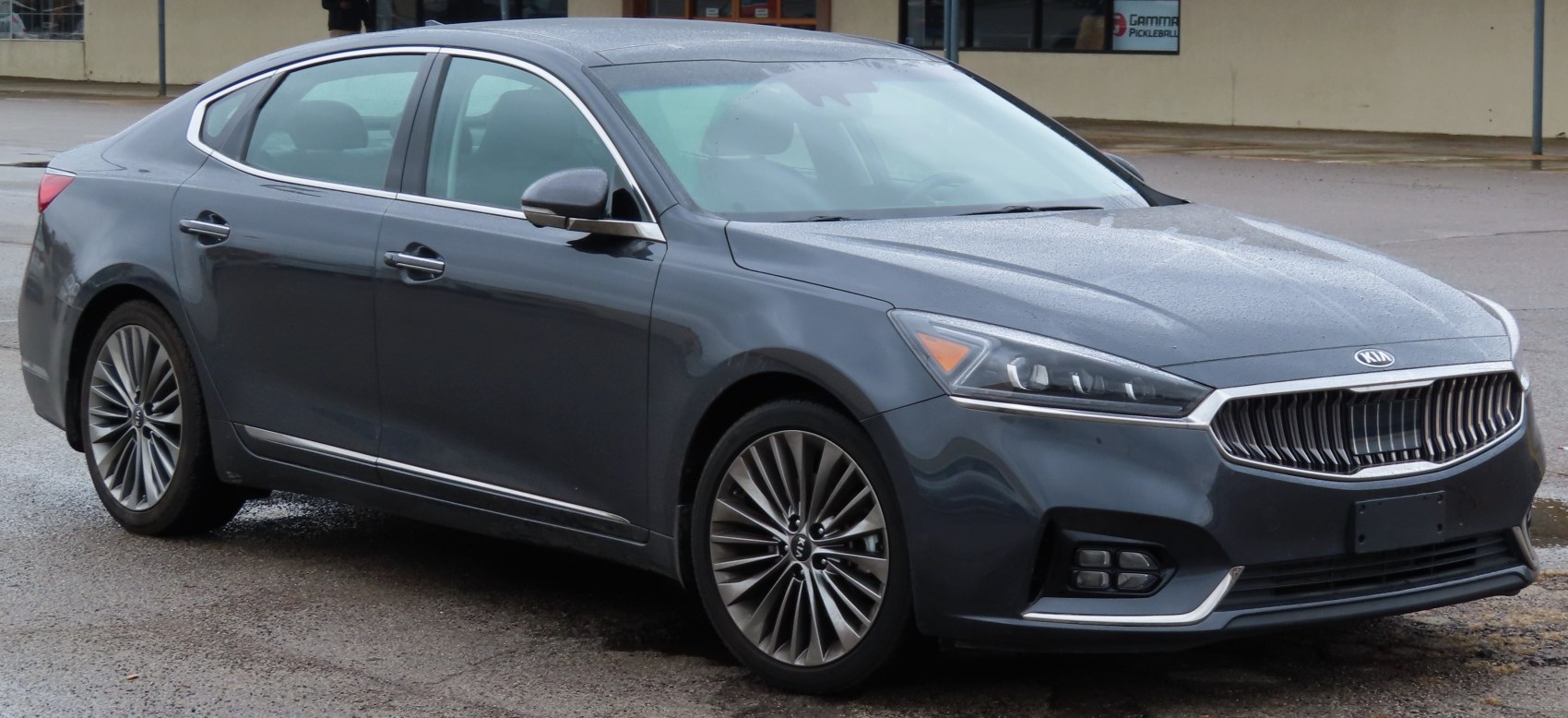 Front-side view of a sleek luxury sedan with distinctive grille and alloy wheels