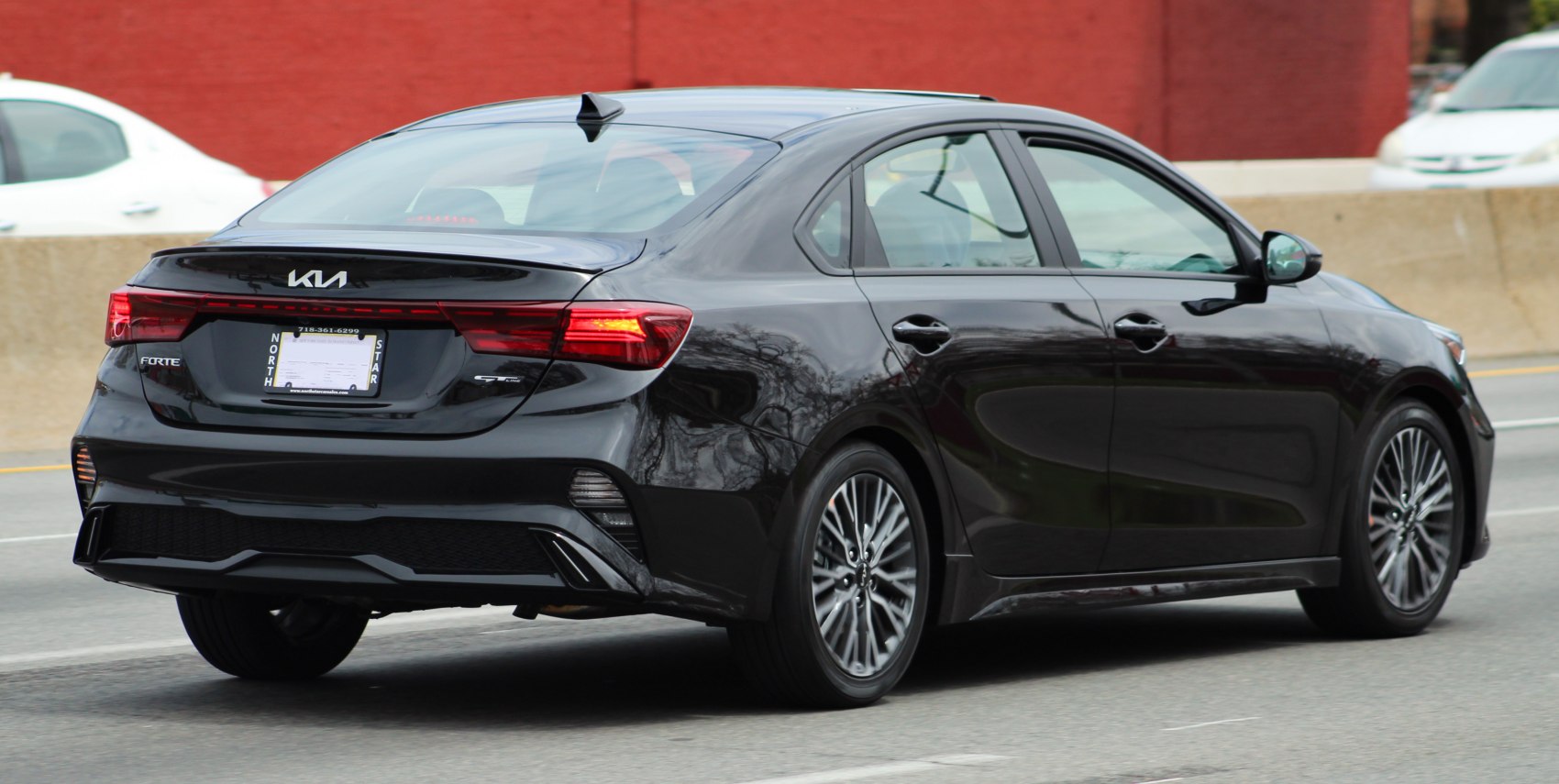 Rear view of a sleek black sedan with modern tail lights and sporty styling.