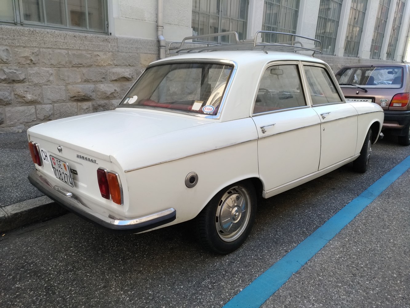 Rear and side view of a vintage 1970 sedan with roof rack and chrome details
