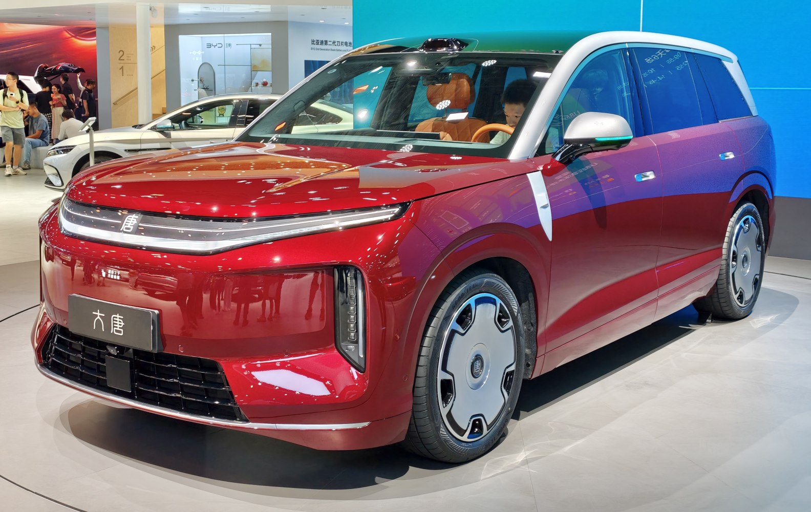 Sleek red SUV with futuristic LED daytime running lights and unique aerodynamic wheels