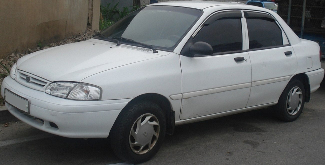 Compact white sedan with distinctive headlights and four doors.