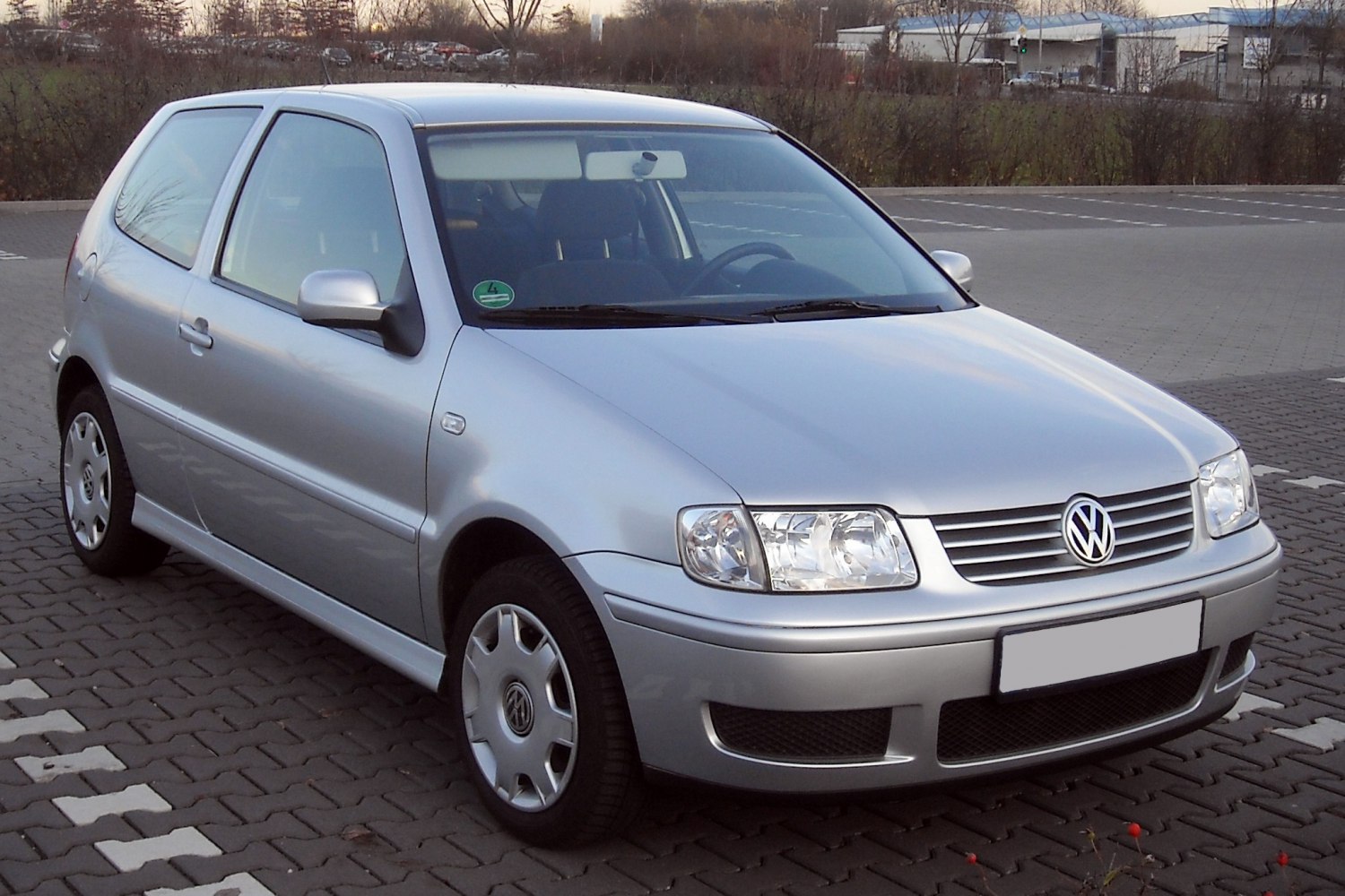 Silver compact hatchback with clear headlights and silver rims