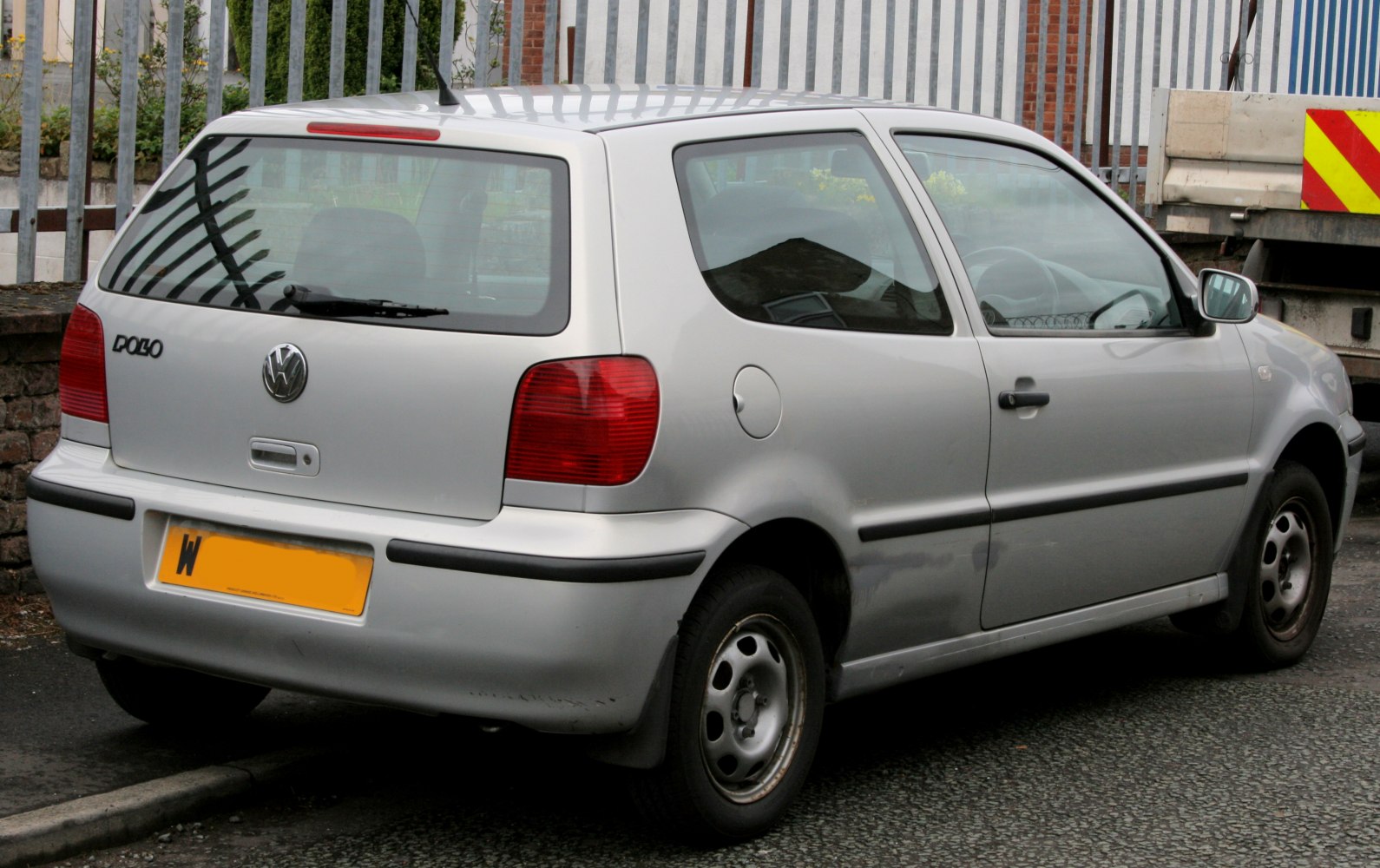 Rear view of compact hatchback with distinctive tail lights and three-door design.