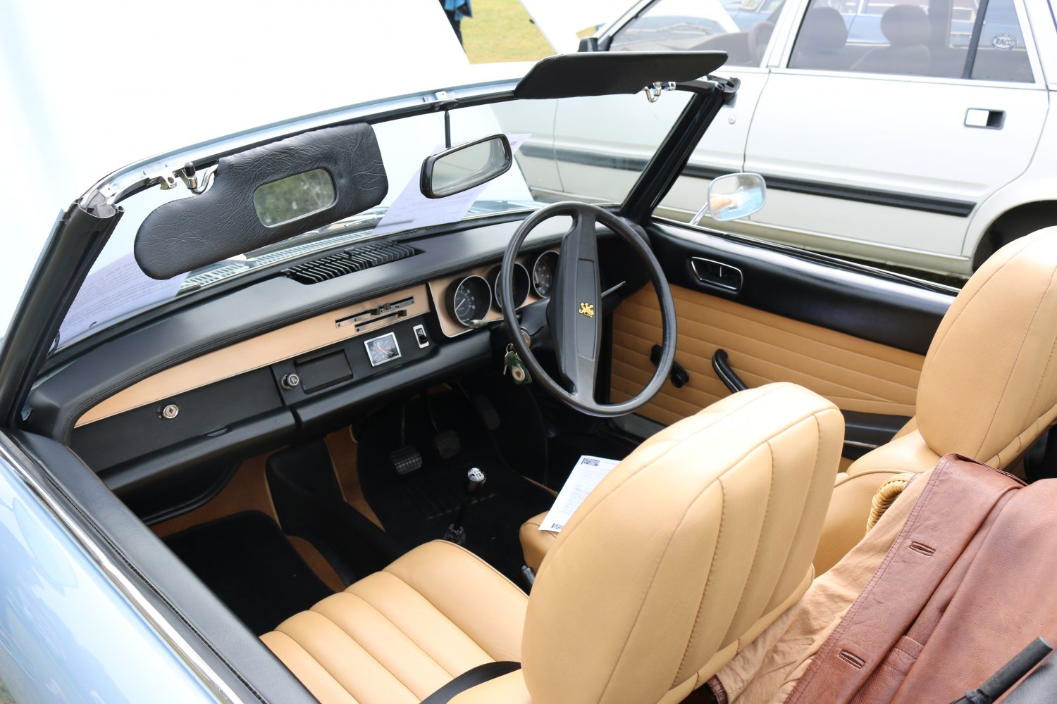 Convertible interior with beige leather seats and vintage dashboard