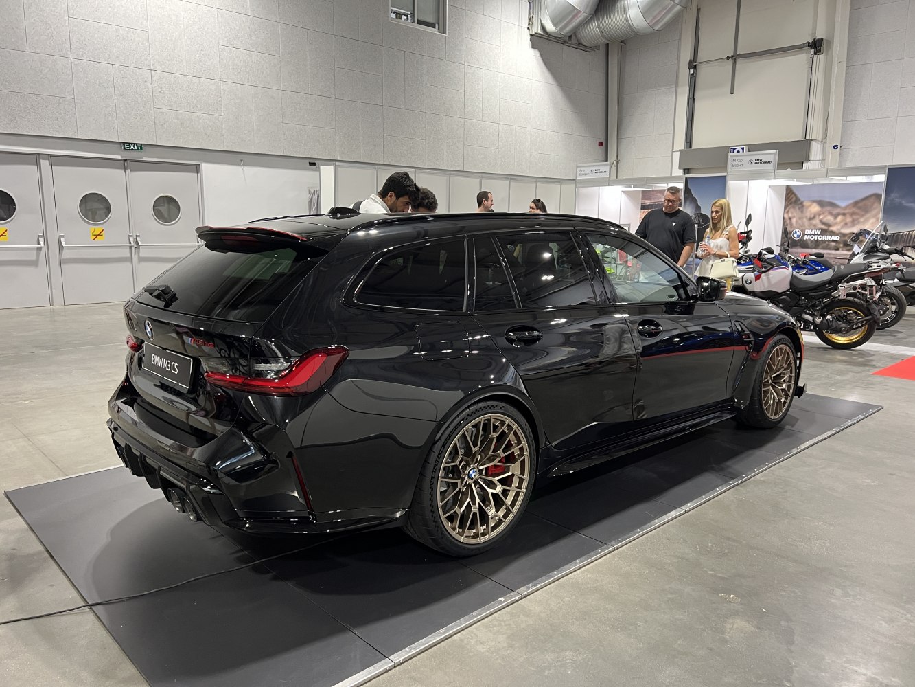Black sport wagon with bronze multi-spoke alloy wheels in indoor showroom