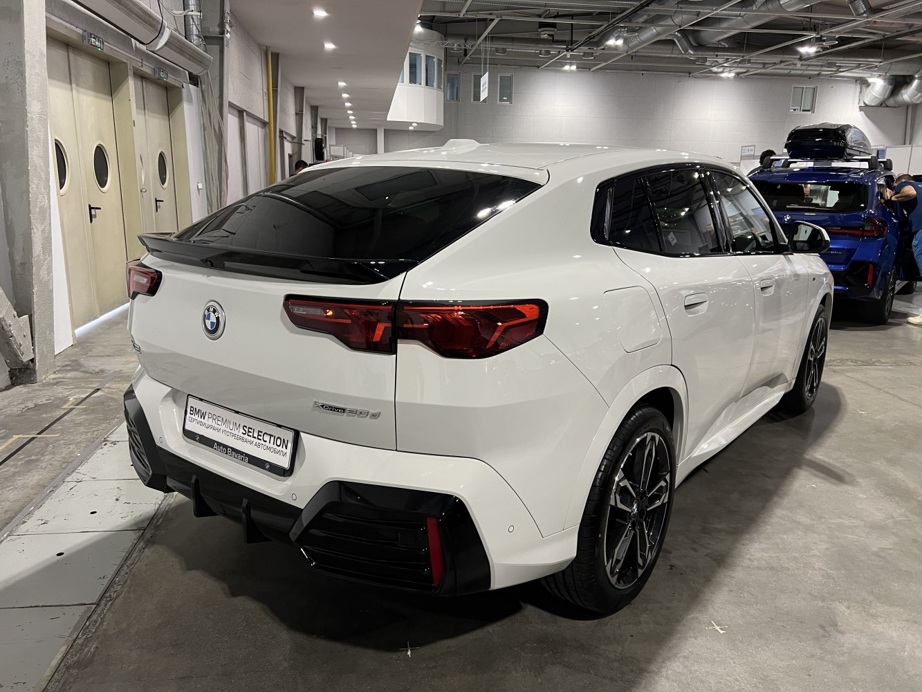 Rear and side view of a white modern SUV with sleek black wheels and aerodynamic design.