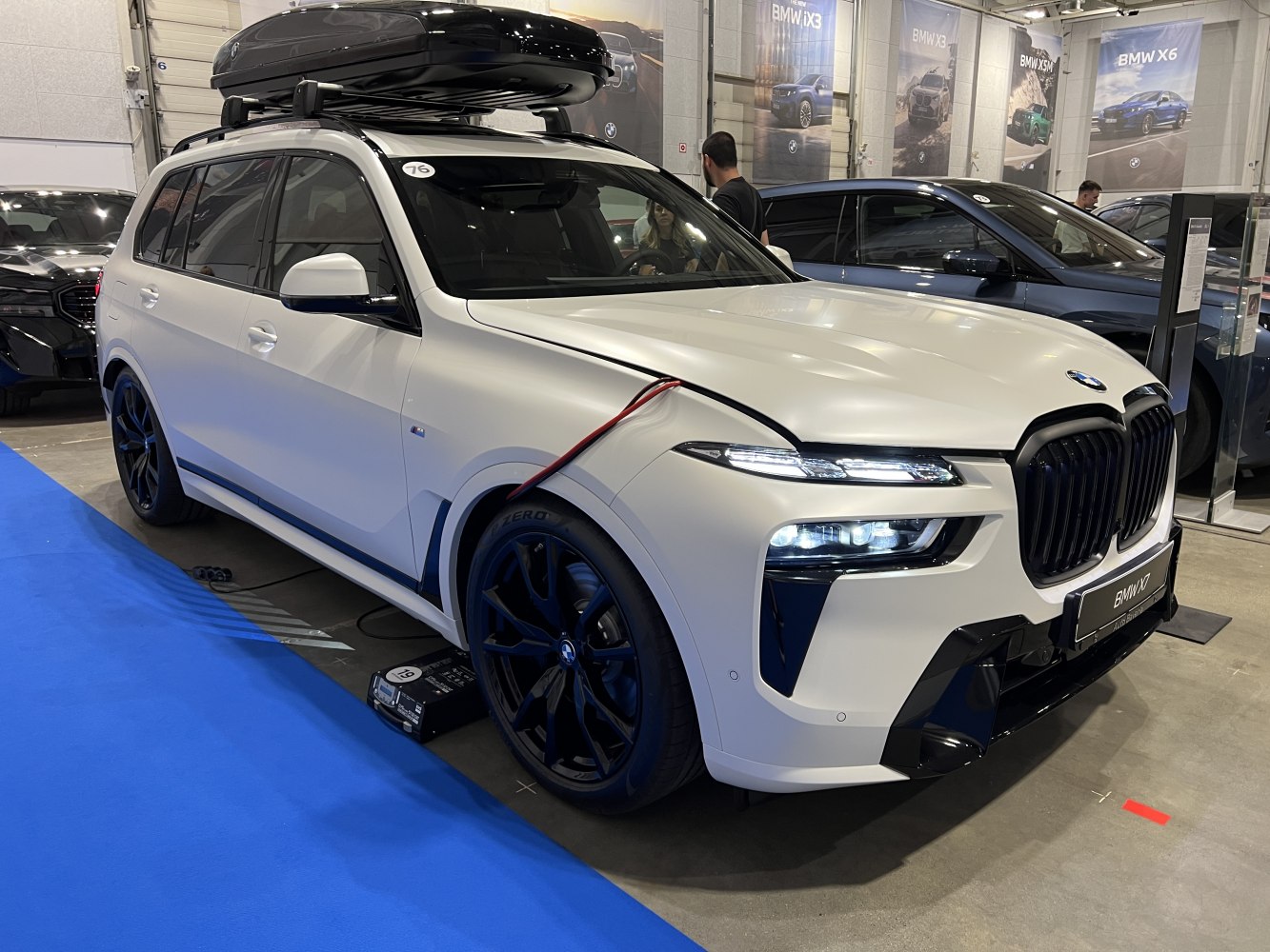 White SUV with roof box and black multi-spoke wheels