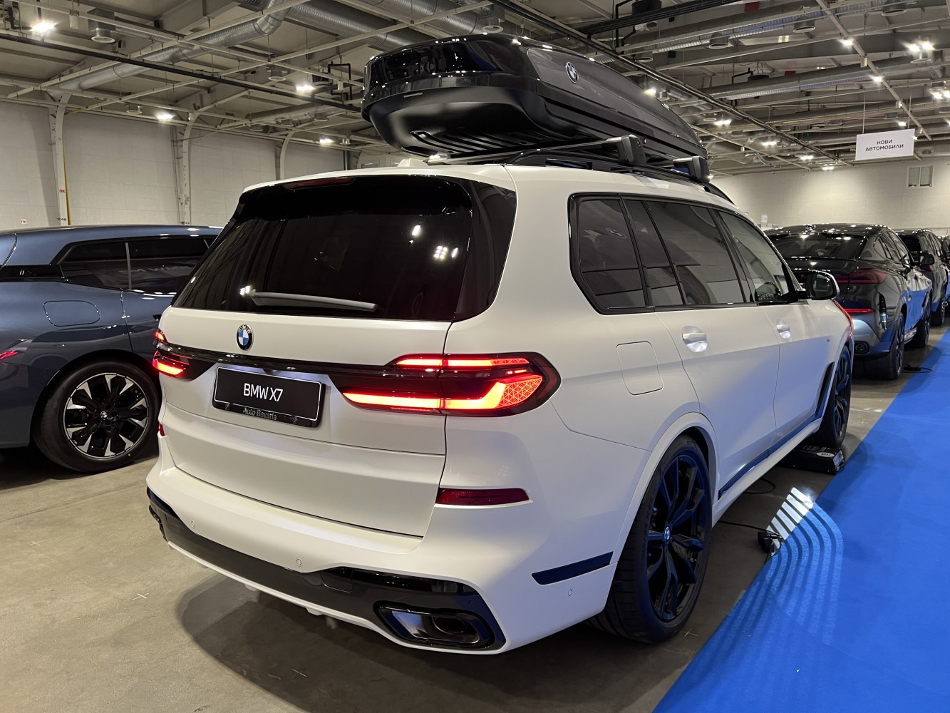 Rear LED taillights and large roof box on white SUV