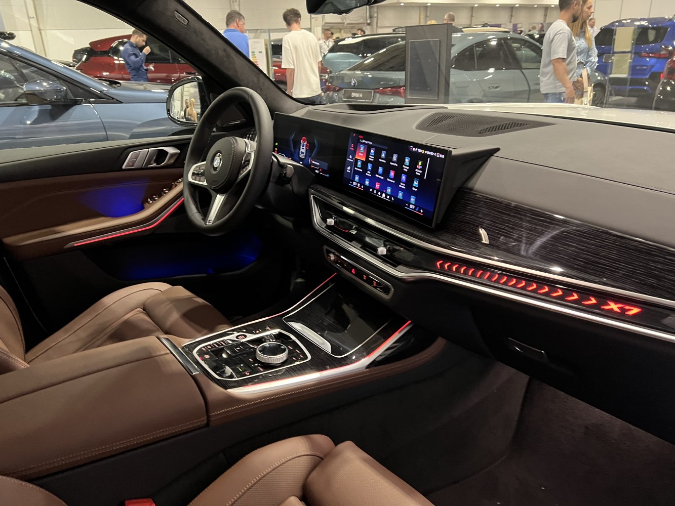 Luxury interior with digital displays, ambient lighting, and brown leather seats