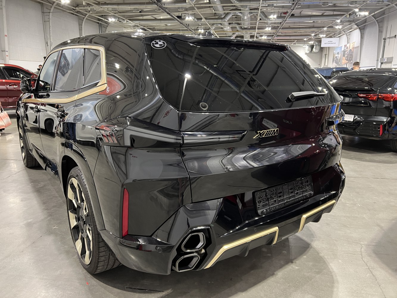Rear view of a black SUV with gold trim and quad exhaust