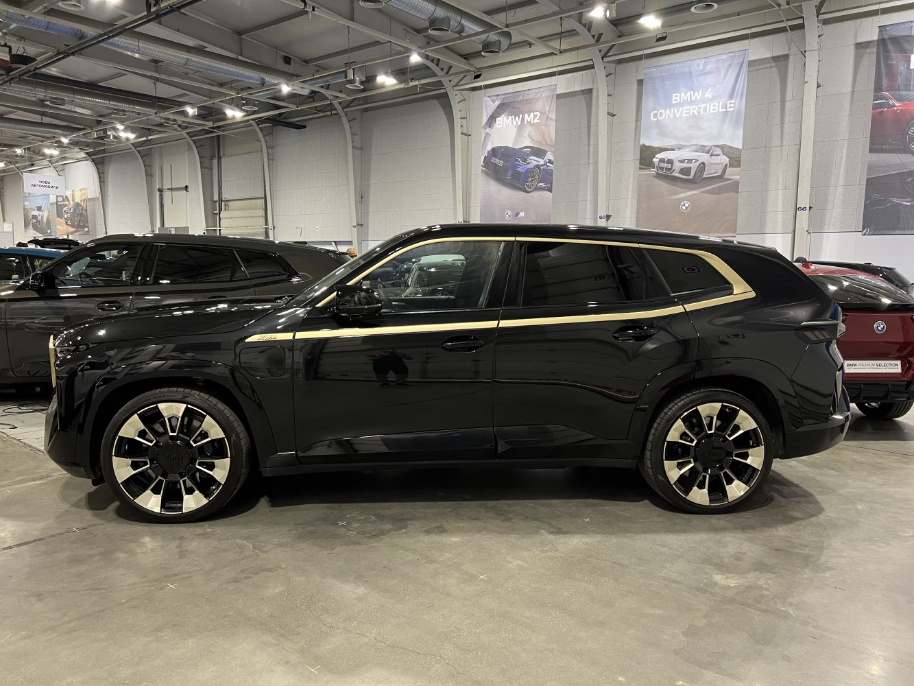 Black SUV with modern alloy wheels and gold trim lines side view