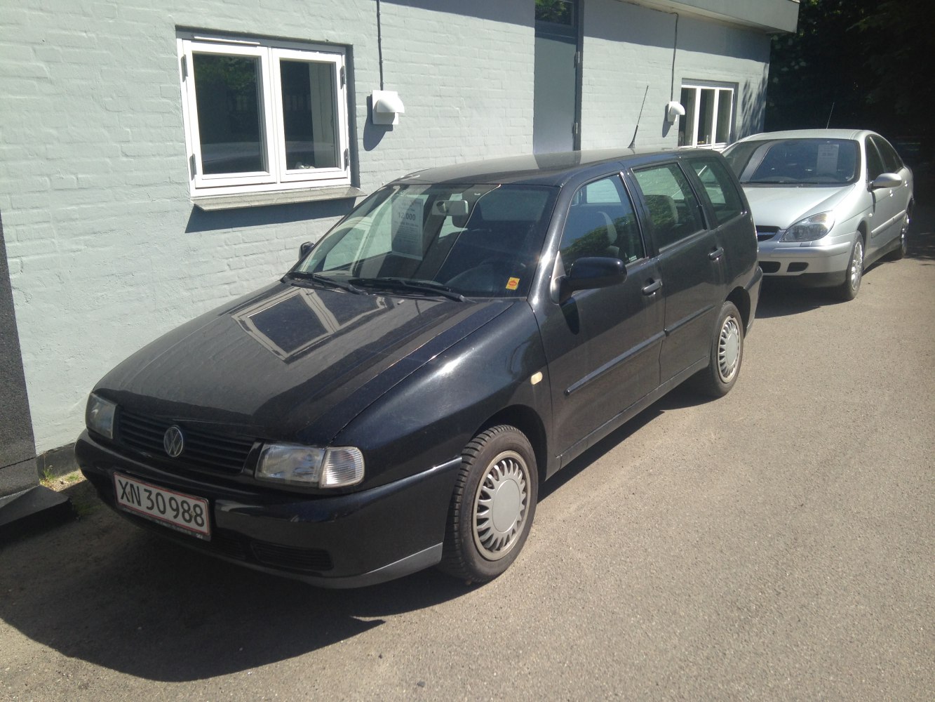 Front and side view of a compact black estate car with practical design.