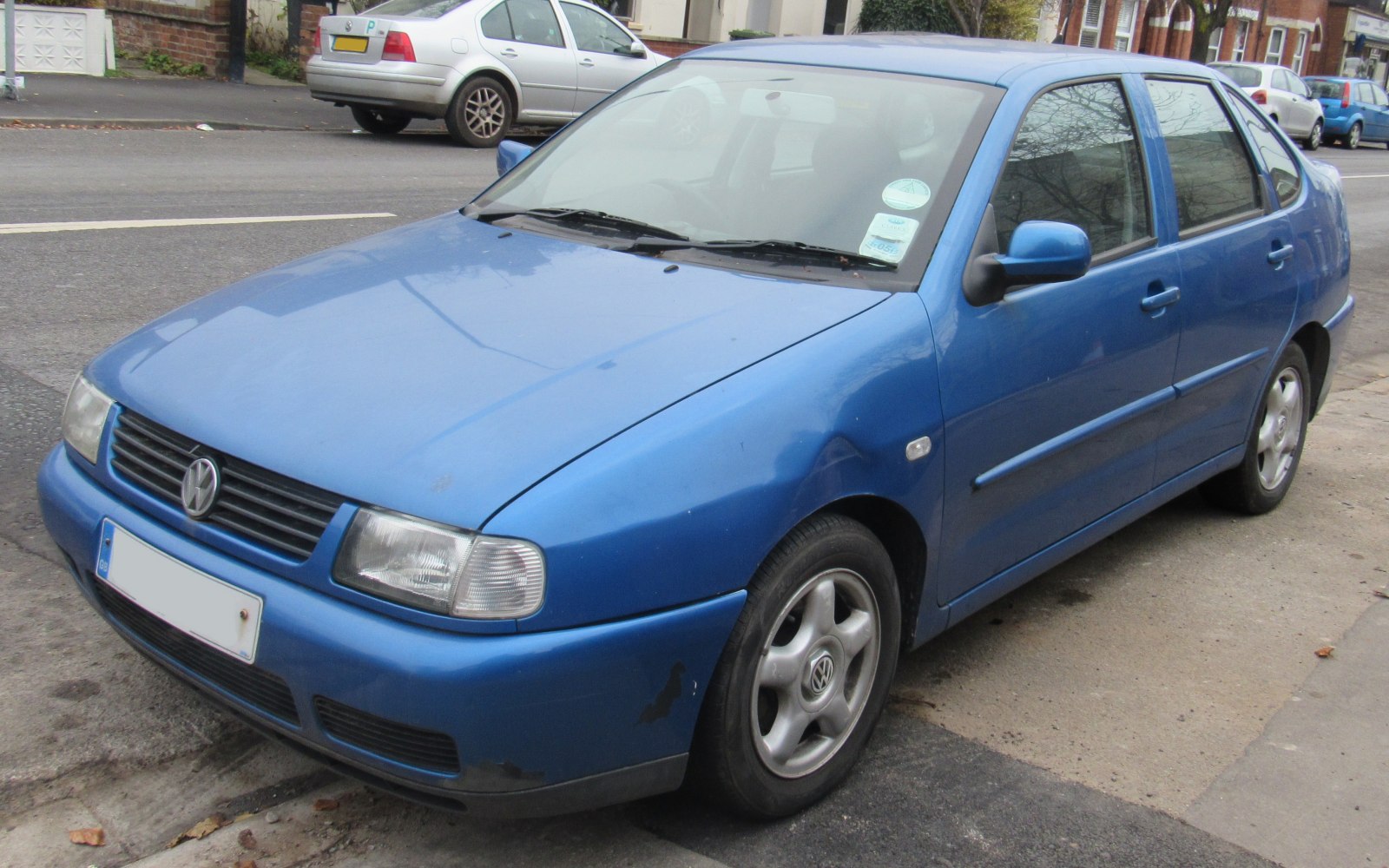 Front side view of a compact hatchback with distinctive headlights and blue paint.