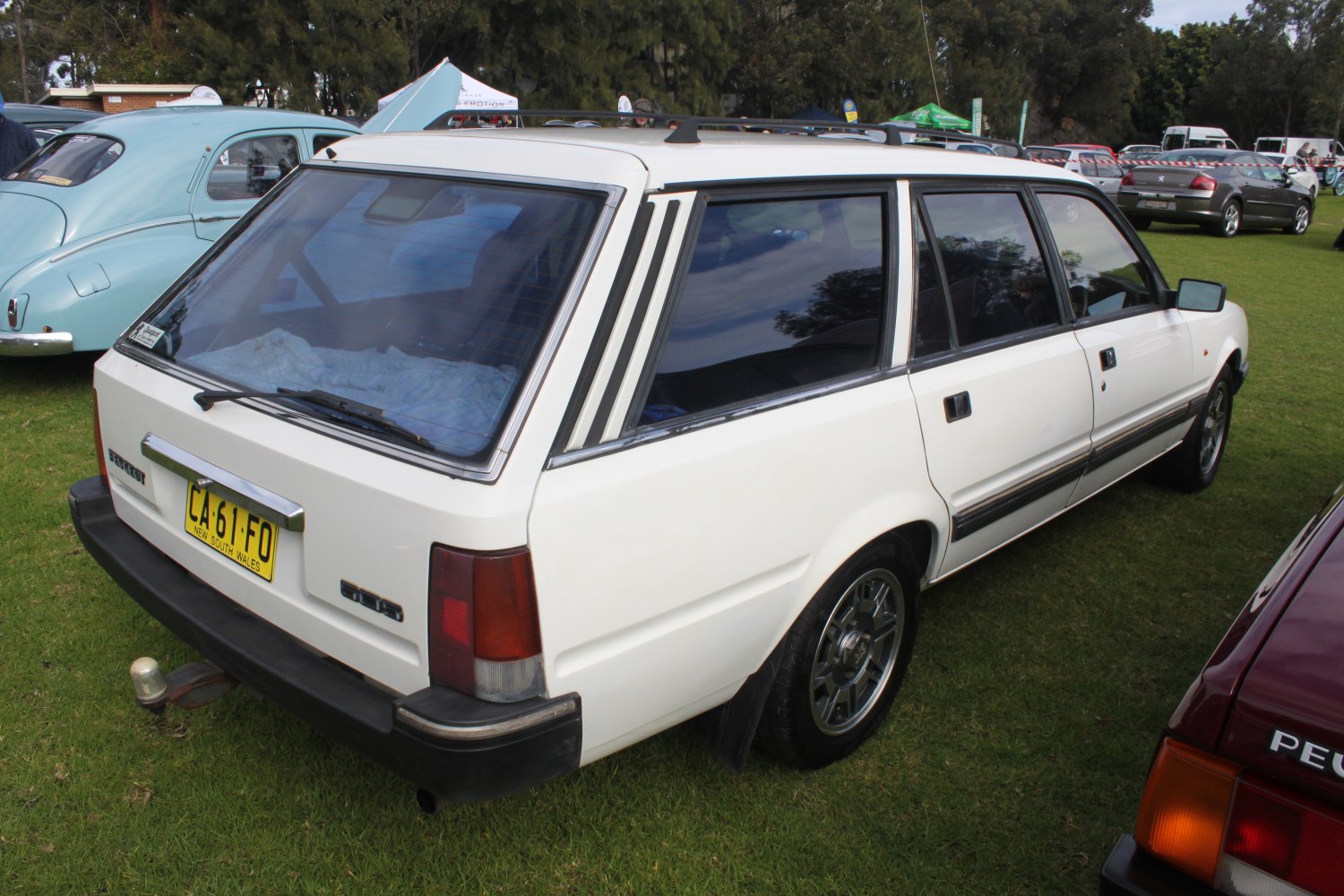 White station wagon with roof rails and rear windshield wiper