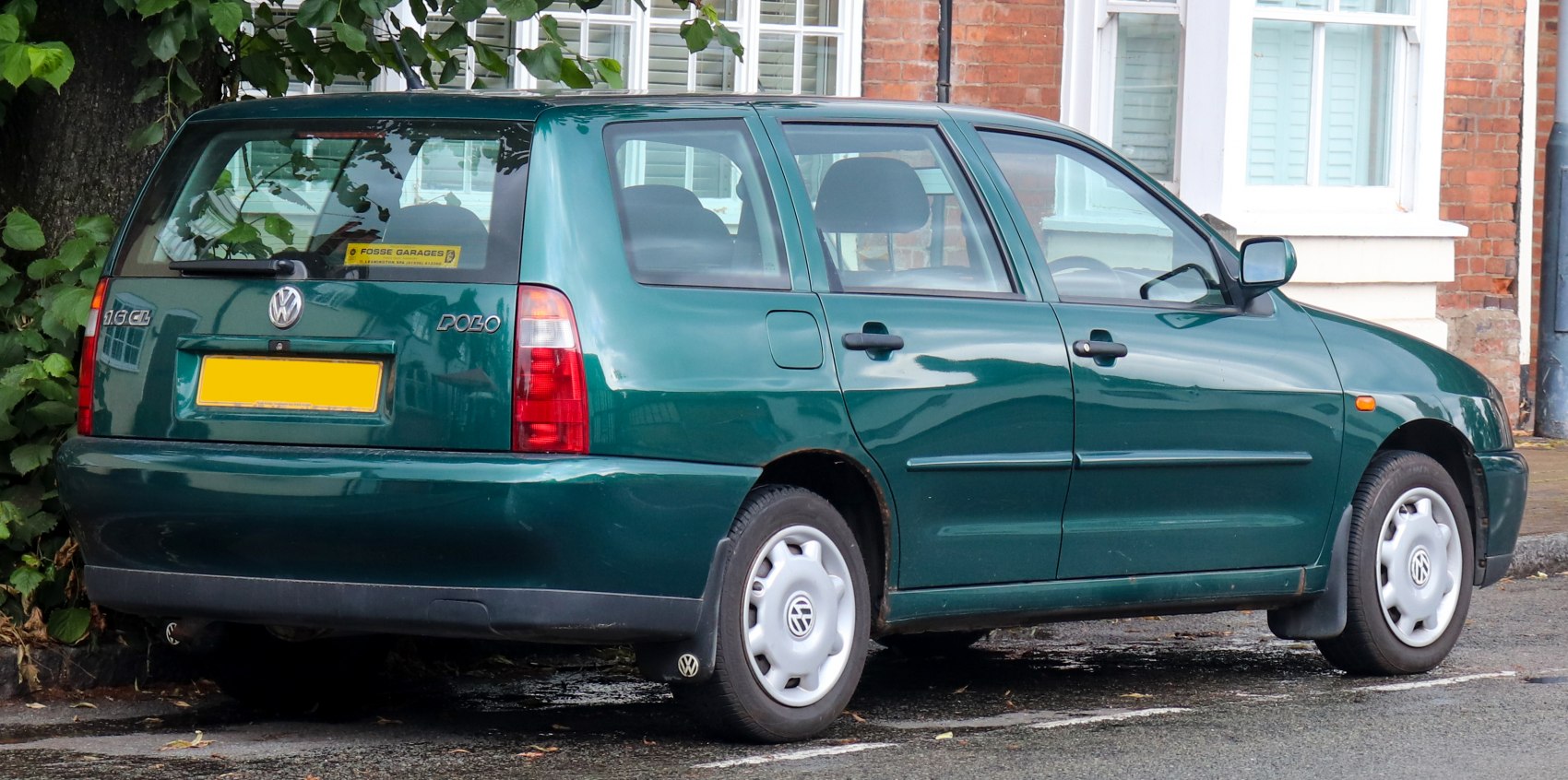 Rear side view of green mid-90s wagon with classic styling