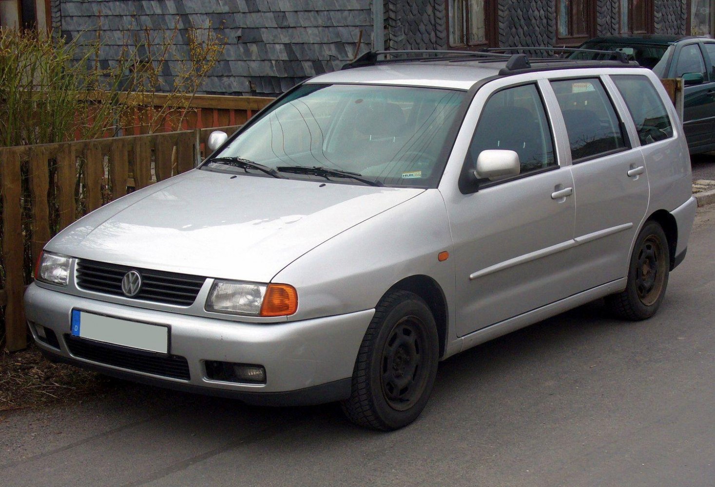 Silver compact station wagon with roof rails, front and side view.