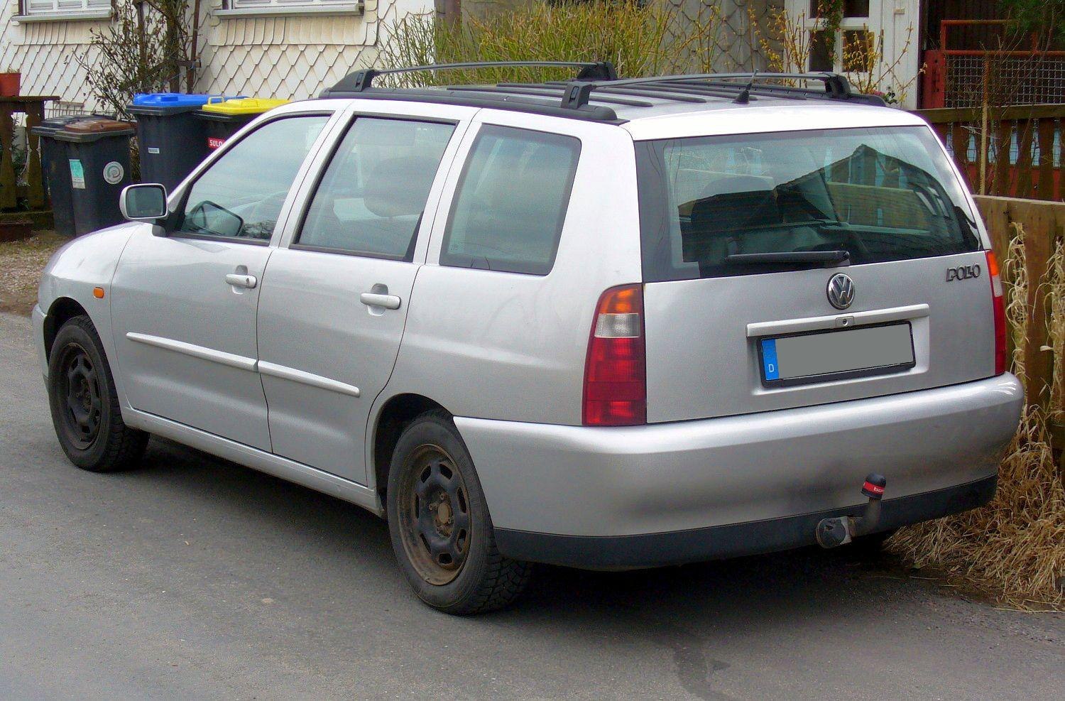 Rear-side view of a compact silver station wagon with roof rails and tow hitch