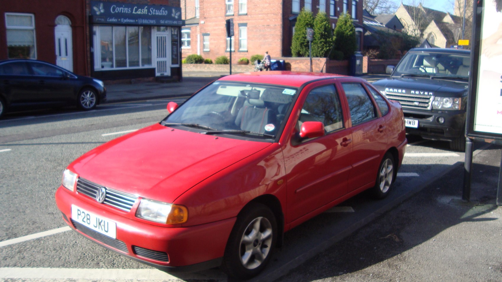 Red compact hatchback with front side view and classic 90s design