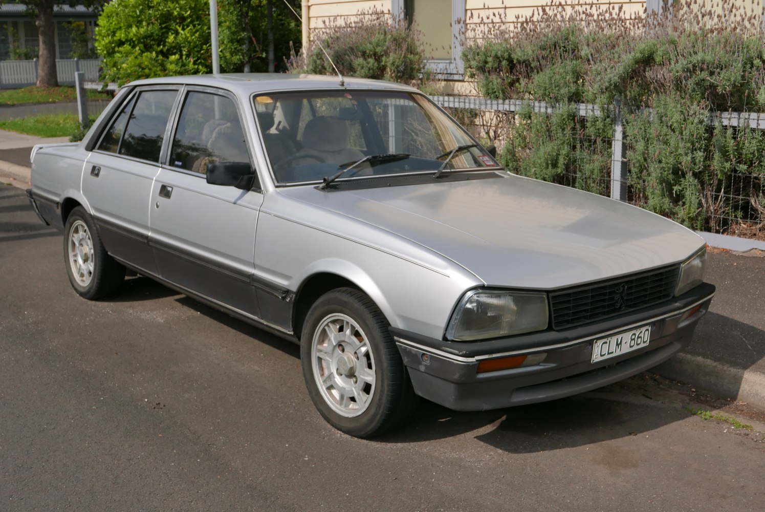 Angular headlights, alloy wheels, vintage 1980s sedan front-side view
