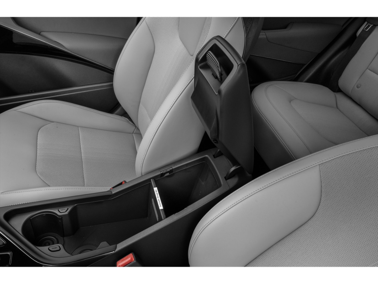 Center console storage compartment with cup holders and padded car seats.