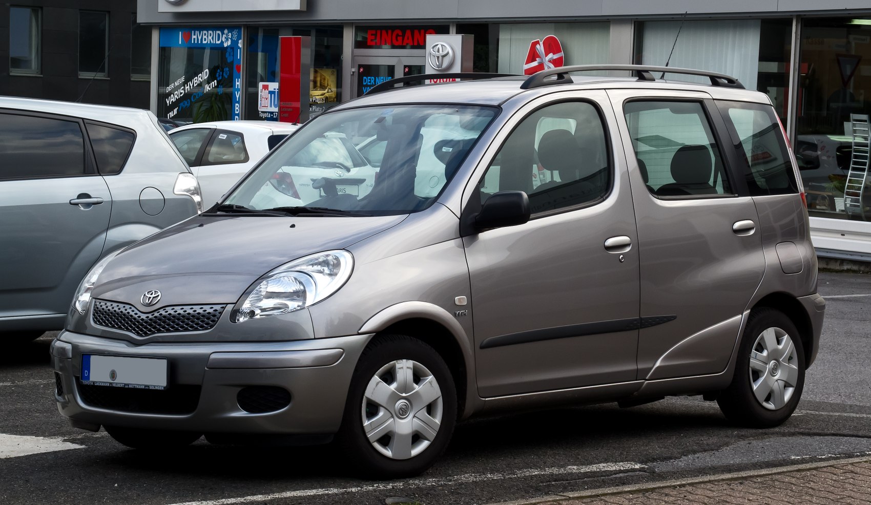 Front-side view of compact MPV with rounded headlights and roof rails