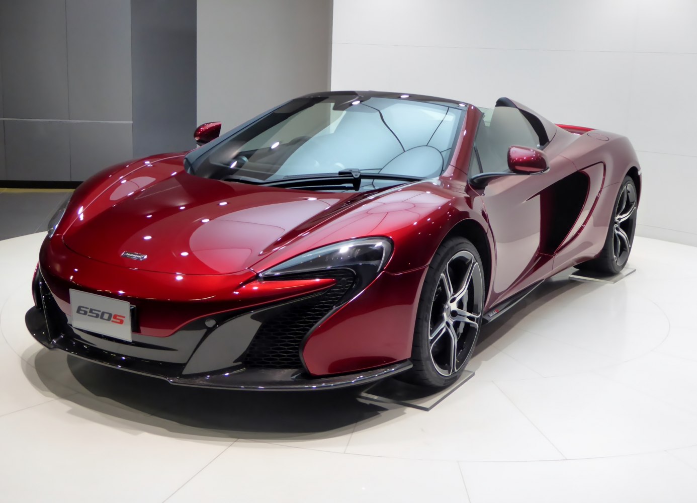 Front-side view of a convertible sports car with aerodynamic lines and aggressive headlights