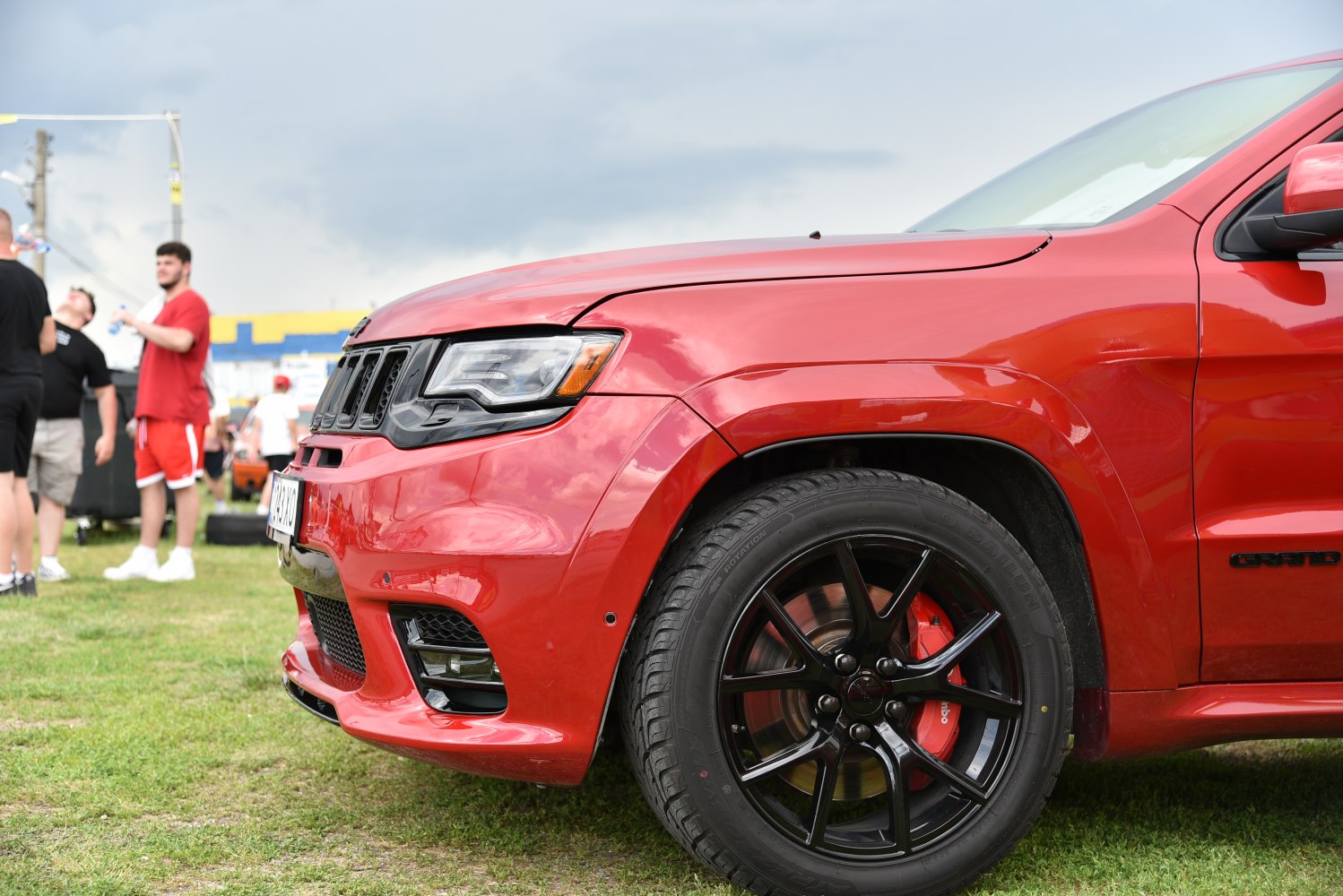 Red SUV front side with black alloy wheel and red brake caliper