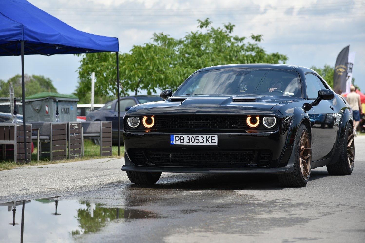 Black muscle car front with halo headlights and hood scoops