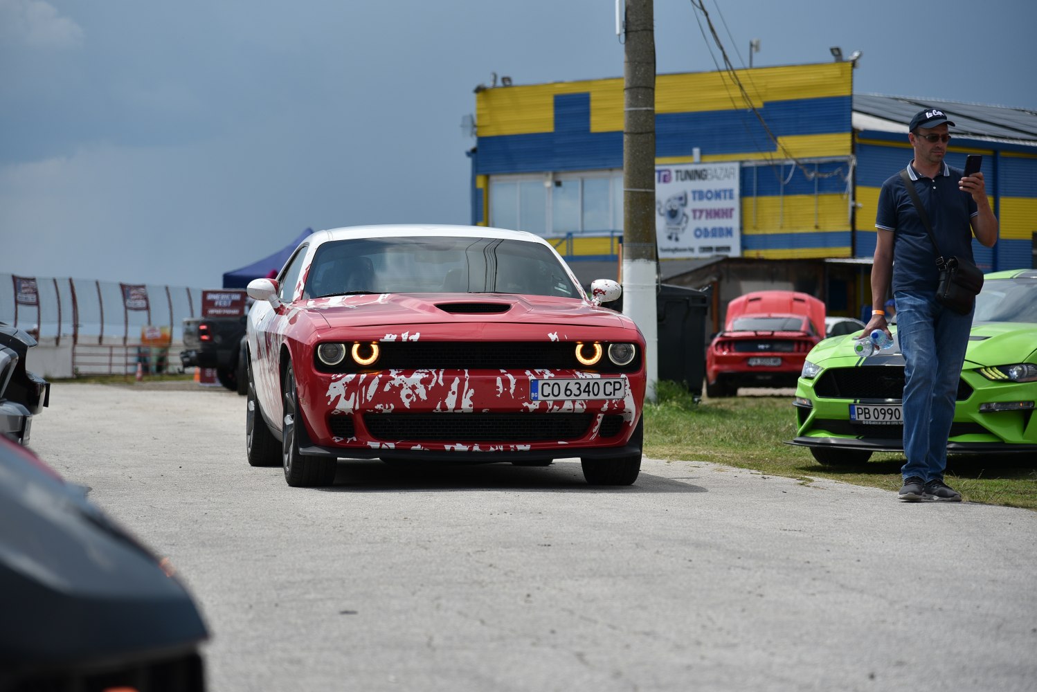 Red muscle car front with halo headlights and white splatter paint