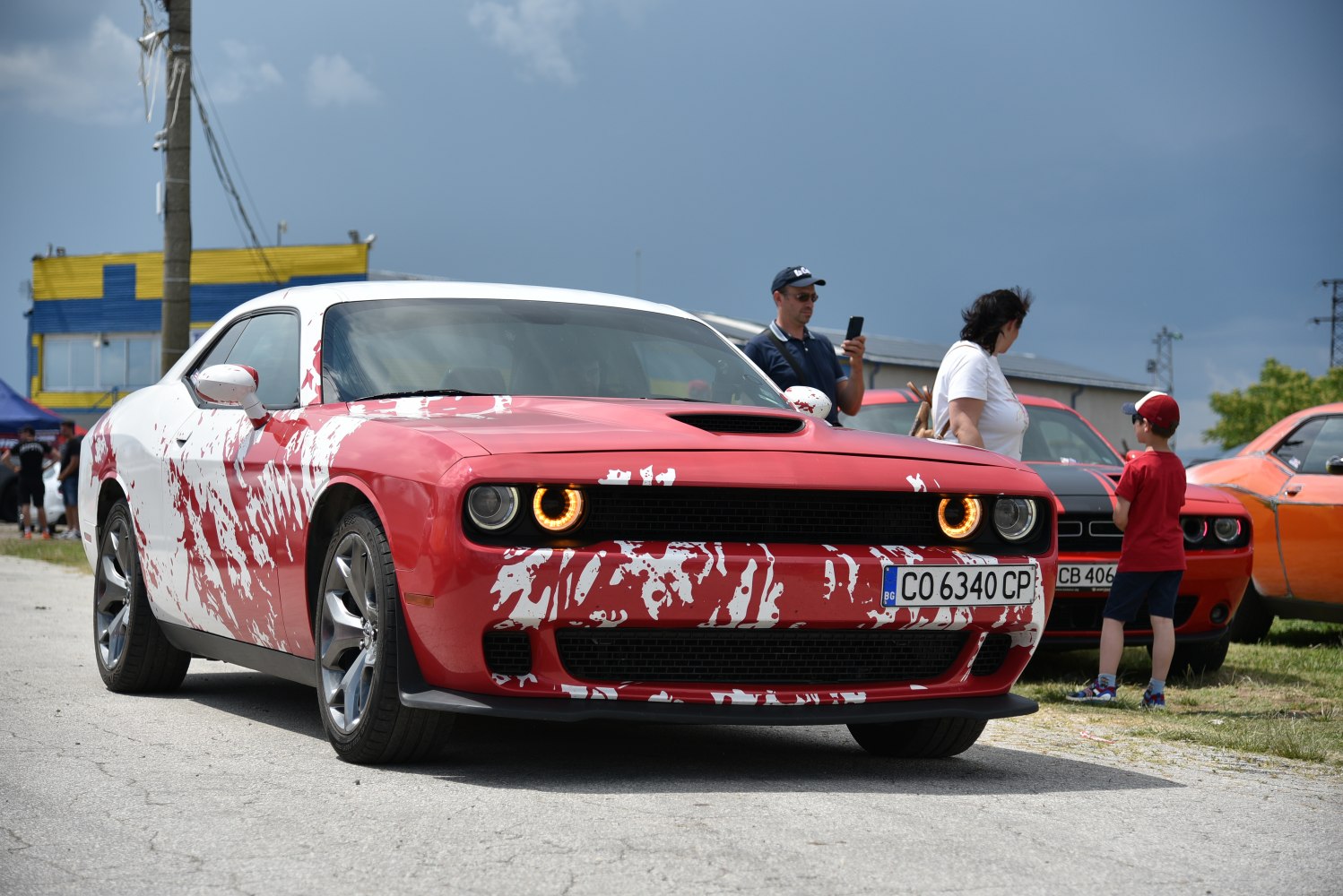 Red and white custom painted muscle car with circular headlights front view