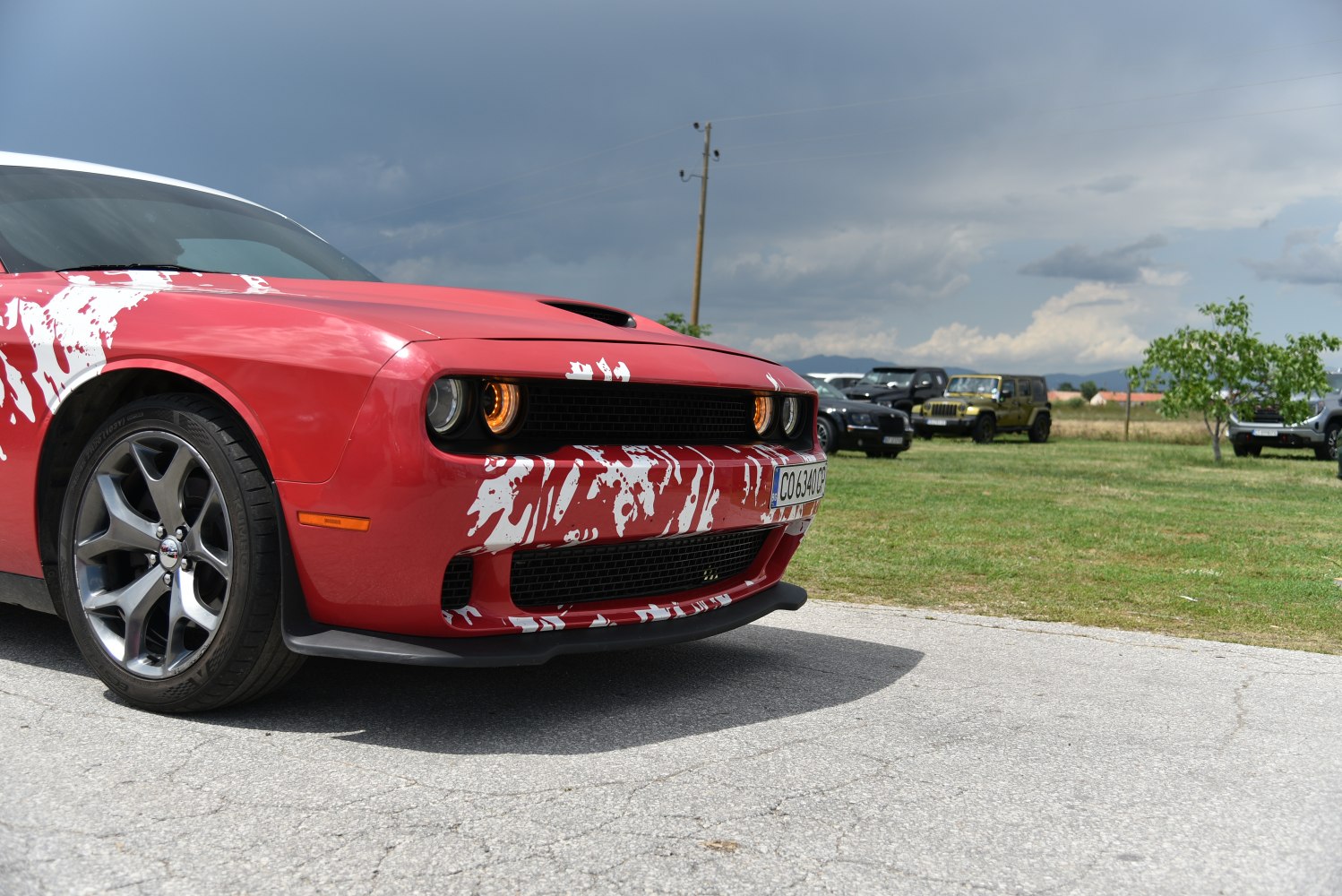 Front design and illuminated headlights of a muscle car with sporty wheels