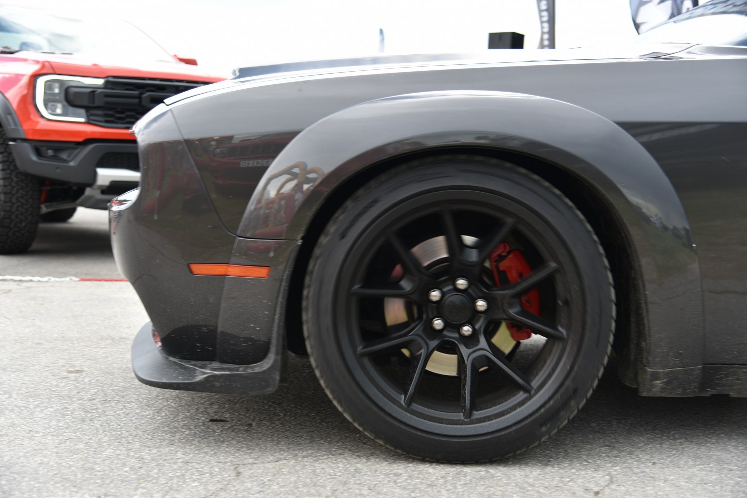 Black alloy wheel with red brake caliper on muscle car