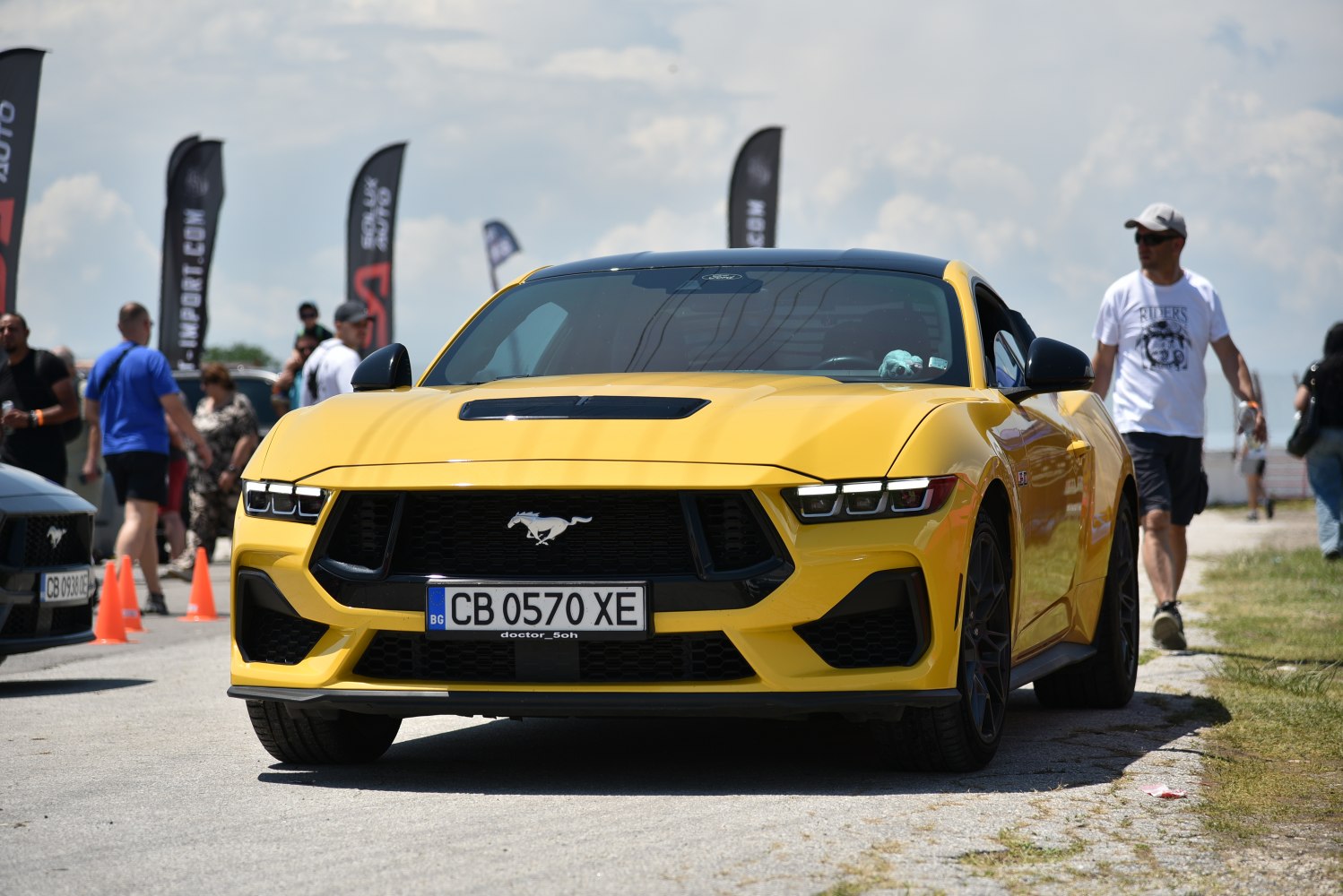 Yellow car front view with aggressive grille and modern LED headlights