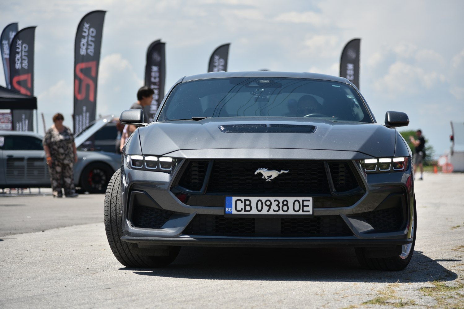 Front view of a sporty car with aggressive grill and sleek headlights