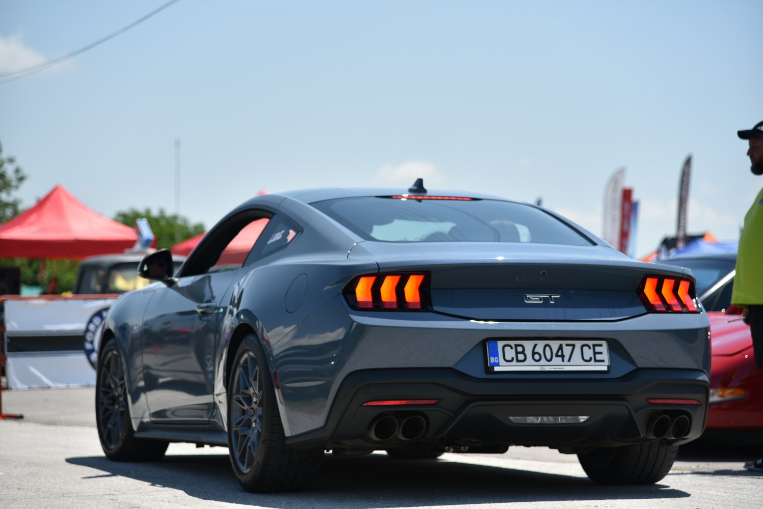 Triple vertical LED taillights and quad exhaust pipes on a sports coupe rear