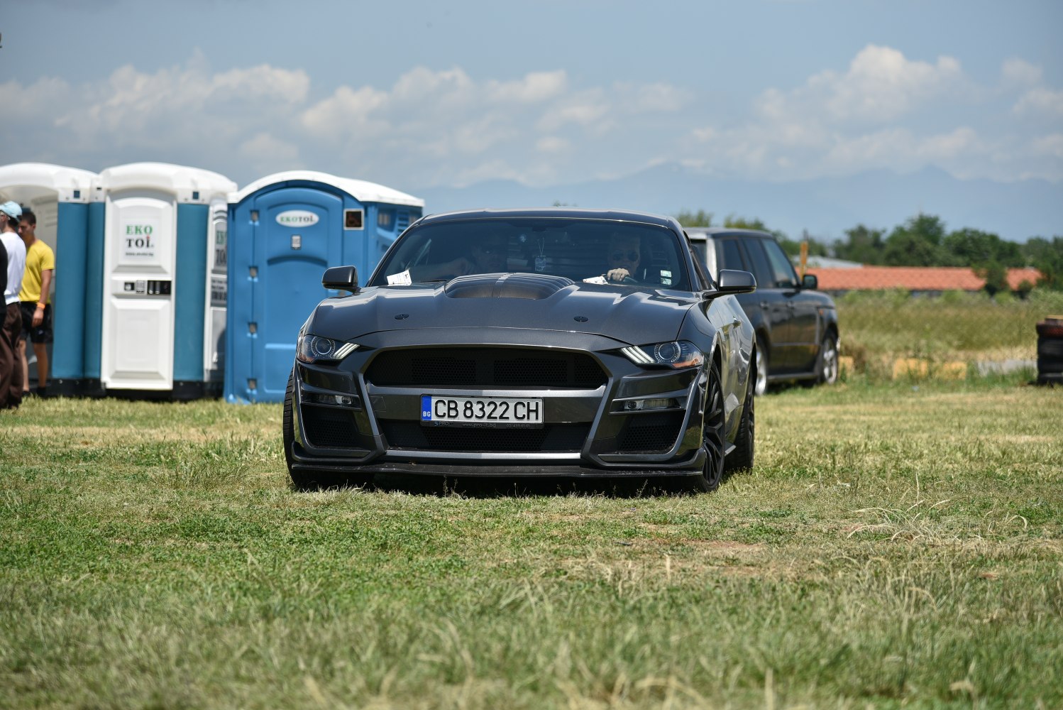 Front view of black muscle car with aggressive hood and wide fenders