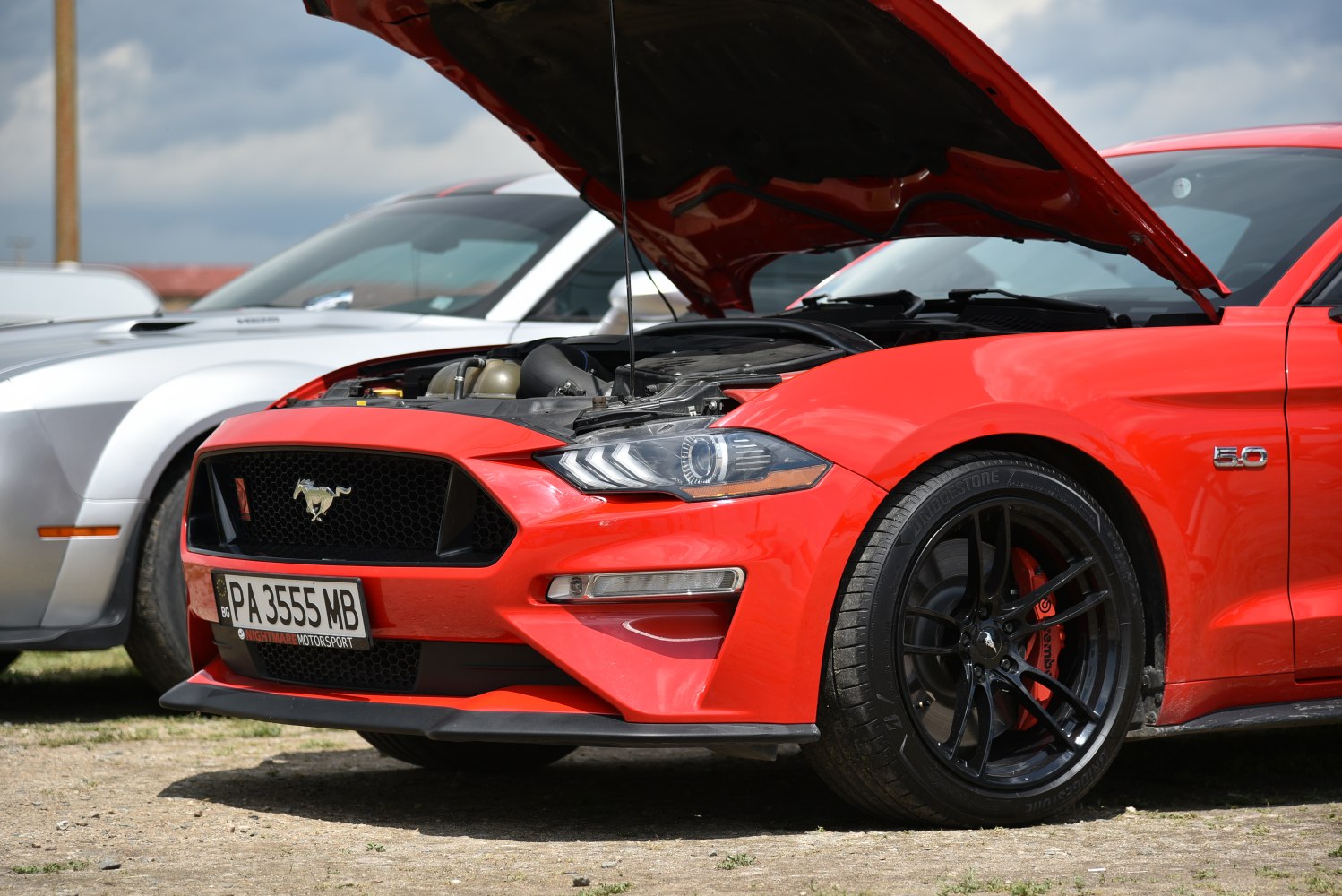 Front view of Mustang with open hood and detailed headlight