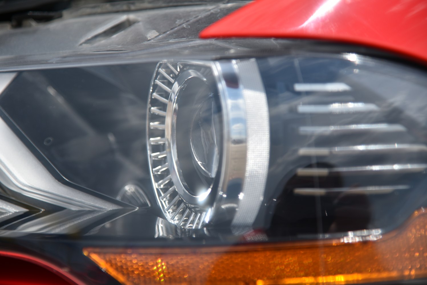 Detailed close-up of a car headlight with chrome accents and integrated amber reflector.
