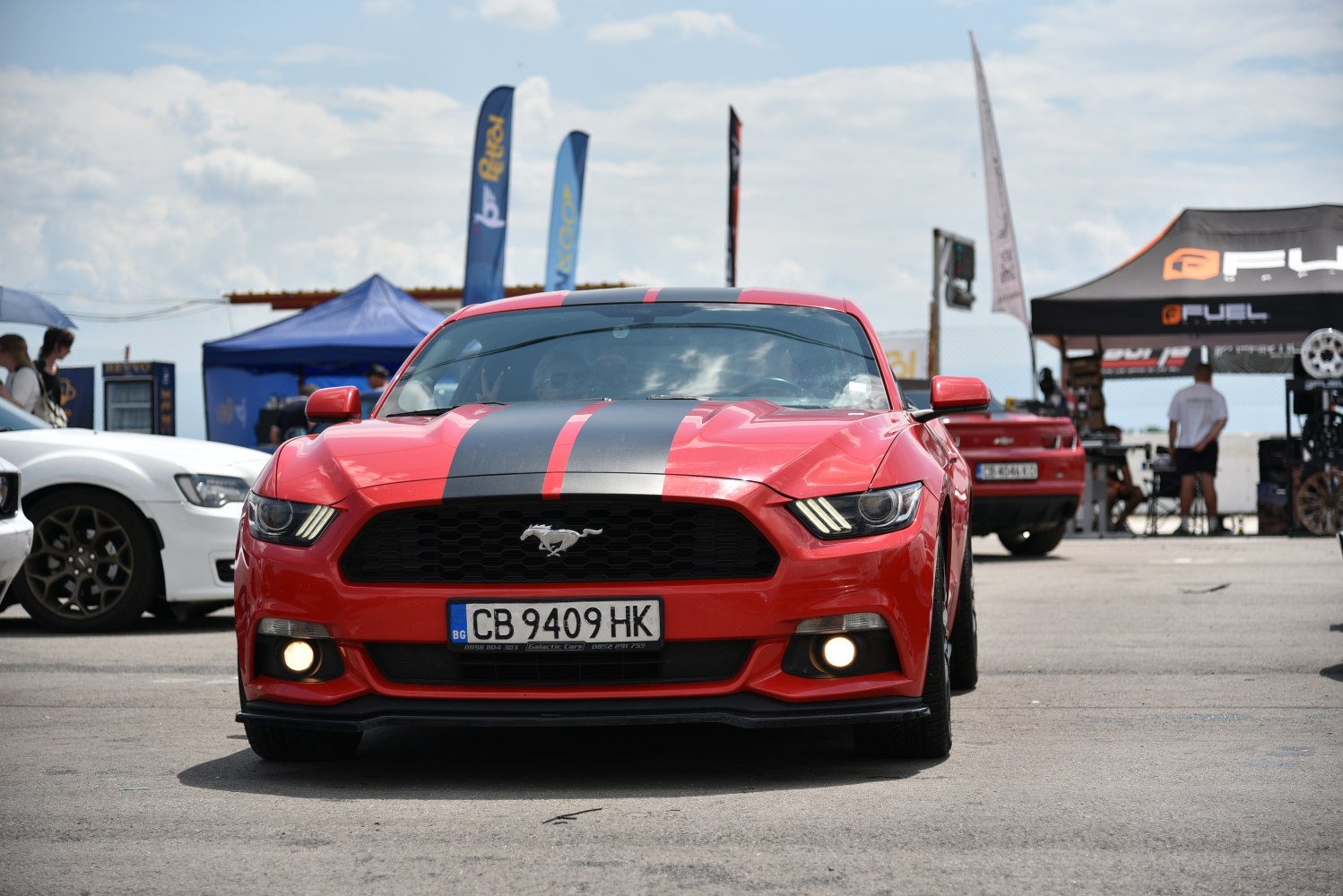 Front view of Mustang with racing stripes and iconic grille emblem