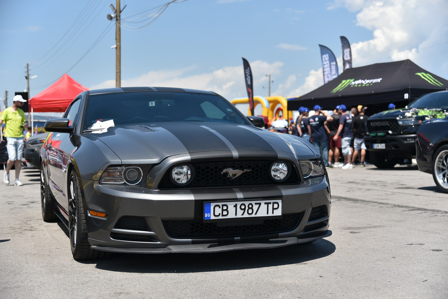 Front grille, headlights, and dual racing stripes on a sporty vehicle.