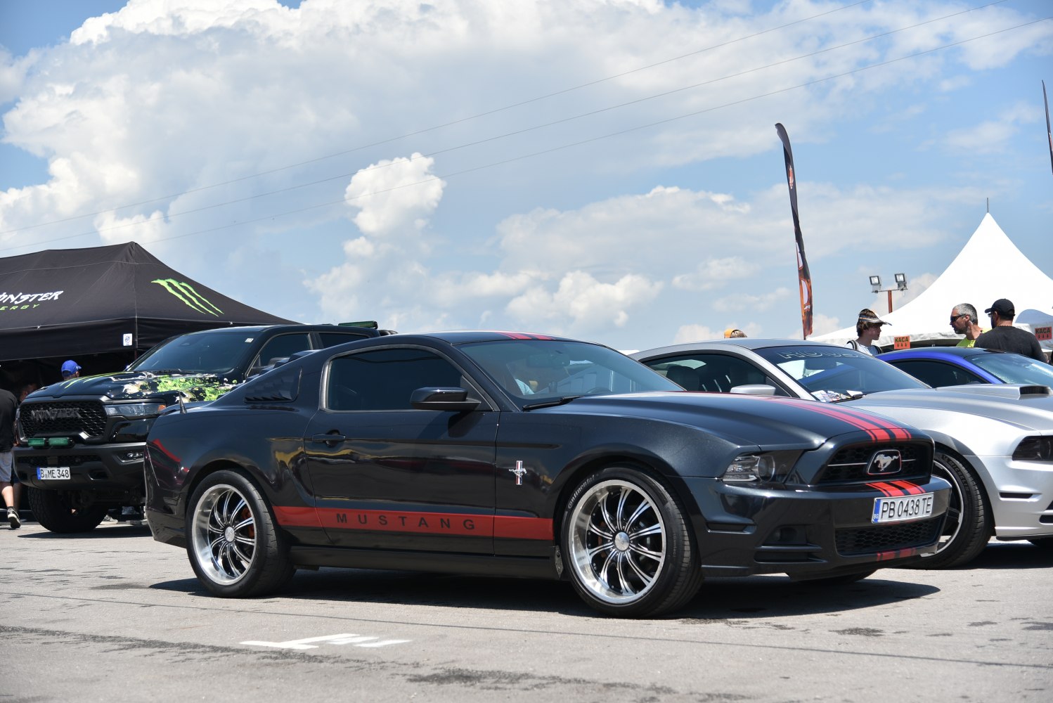 Black Mustang coupe with red racing stripes and alloy wheels