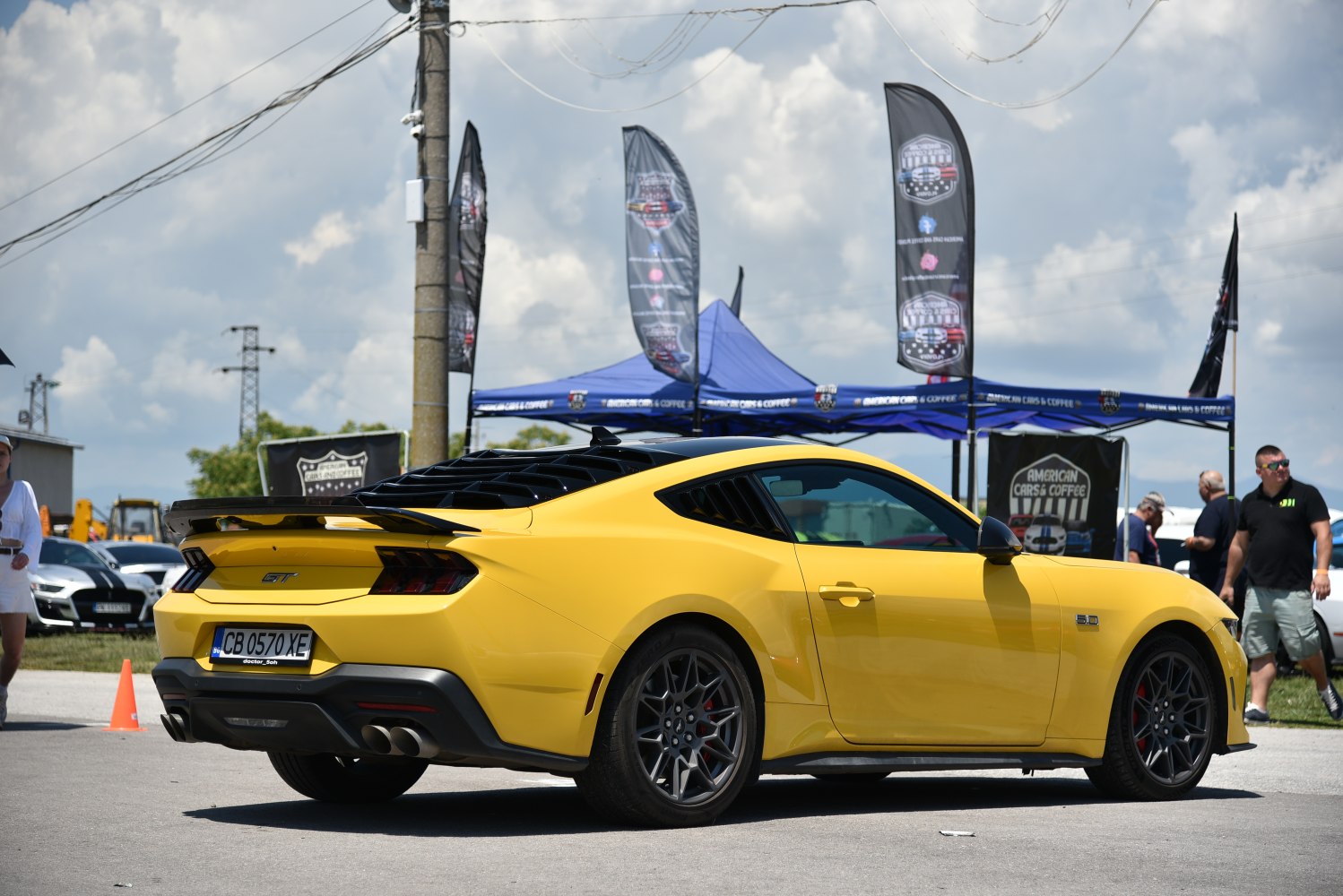 Yellow Mustang VII GT rear side with spoiler and sporty wheels