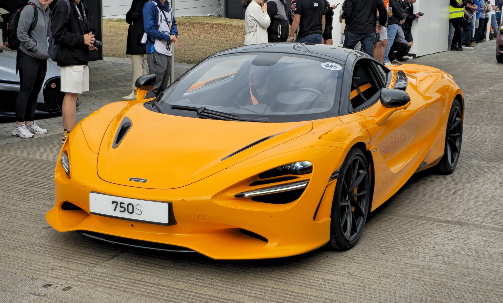 Sleek aerodynamic front design with advanced headlights and vibrant orange paint