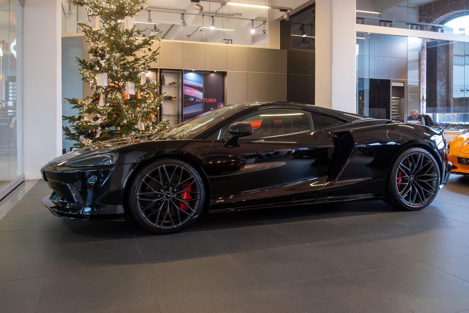 Sleek black sports coupe with aerodynamic design and large alloy wheels.