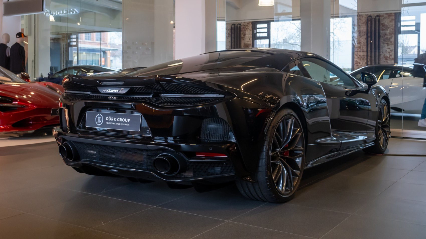 Rear-side view of black high-performance sports car with dual exhausts