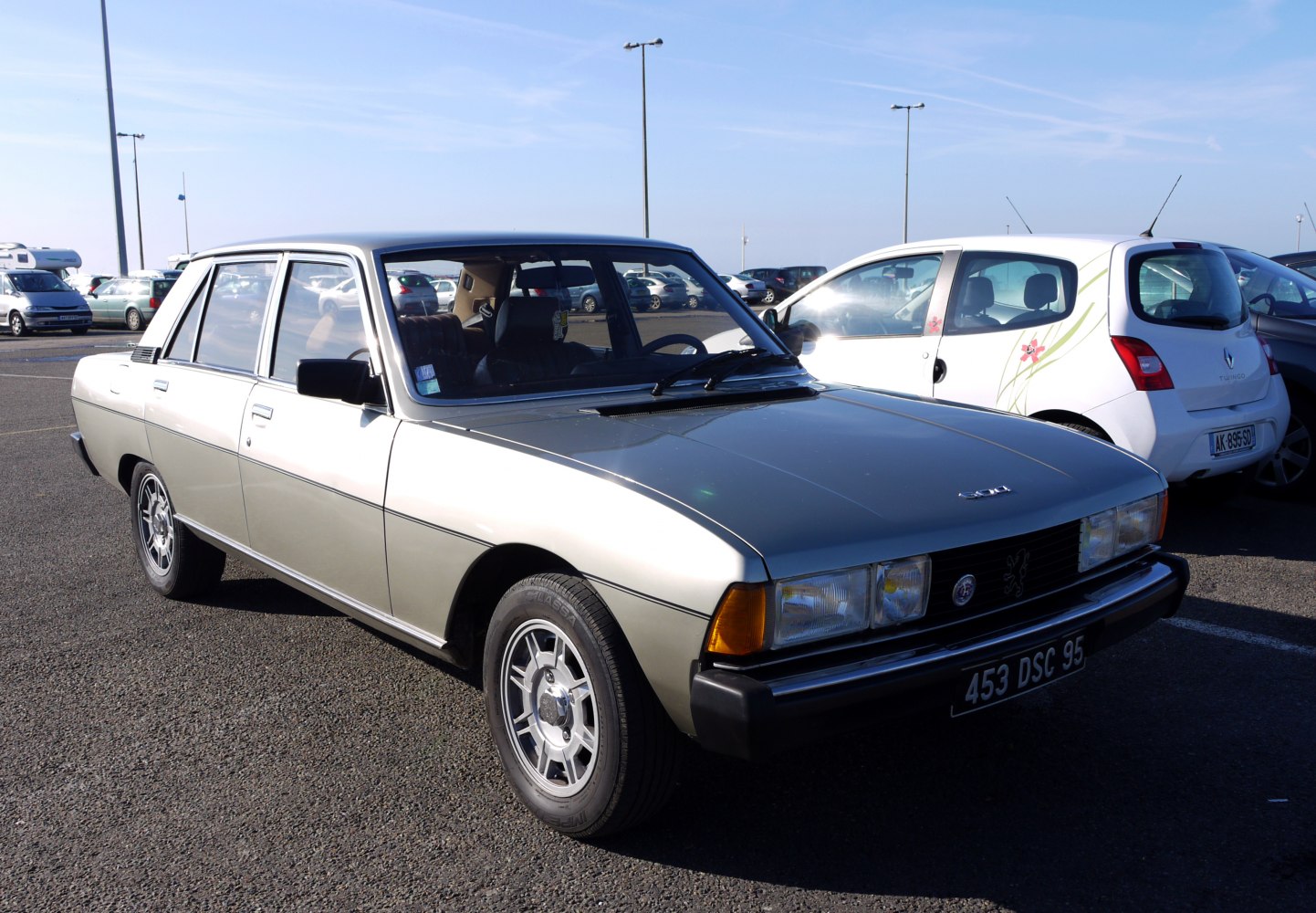Dual rectangular headlights and vintage alloy wheels on a classic boxy sedan.