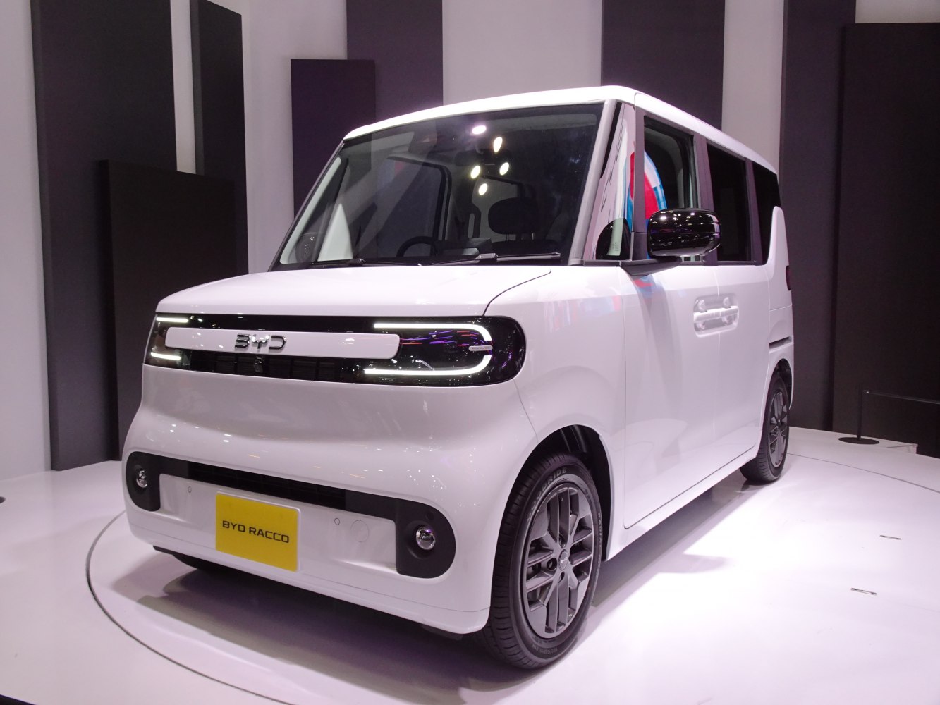 Compact electric urban vehicle with distinctive LED front lights and boxy design